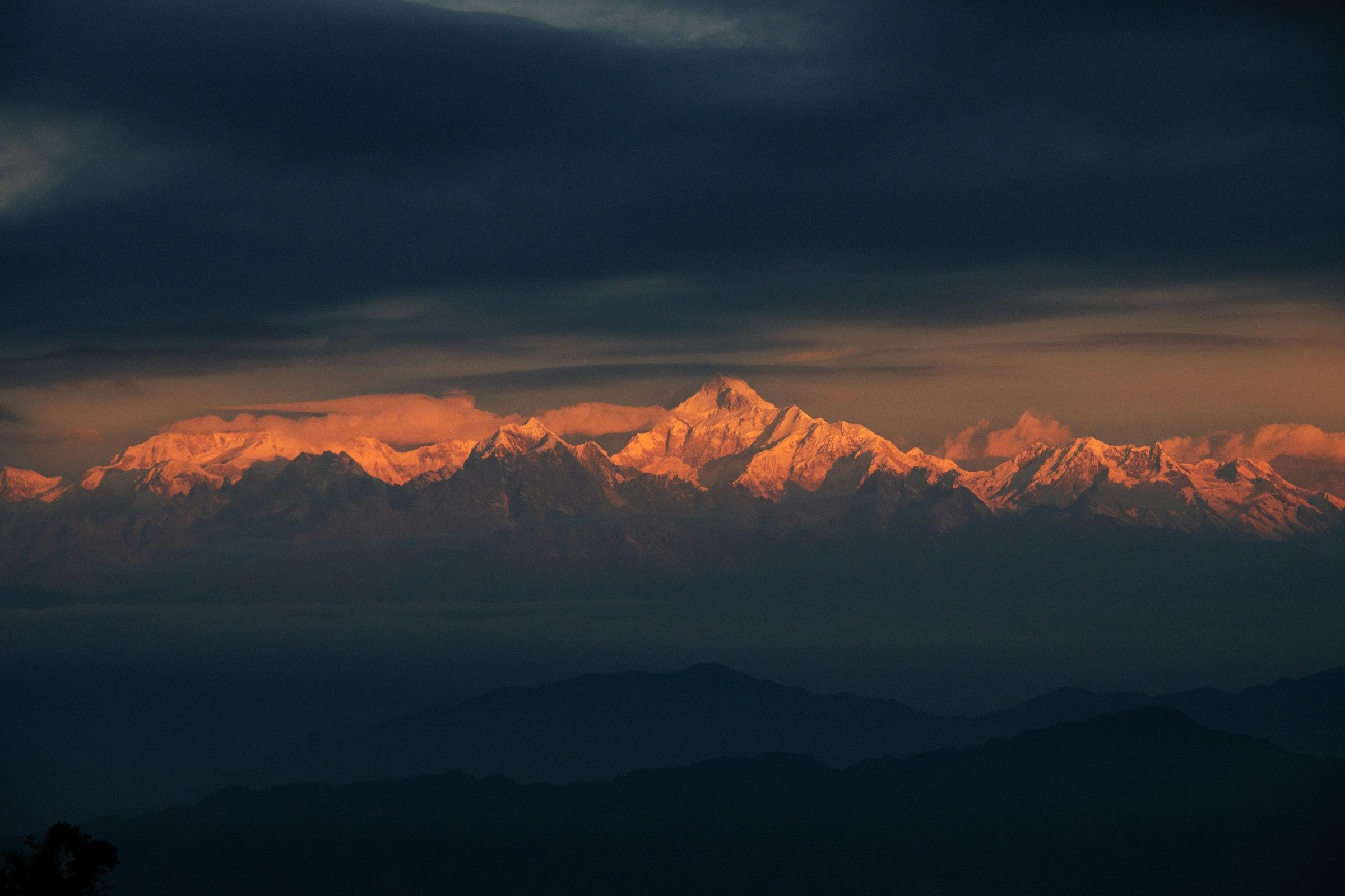 The Kanchenjunga range lit orange by the last of the light, seen from the Darjeeling hills