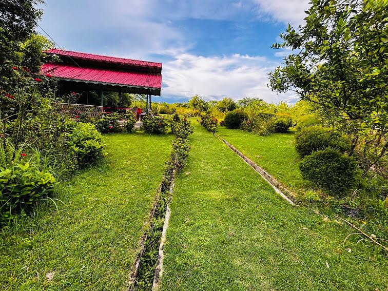 Red-roofed open dining pavilion beside the lawn